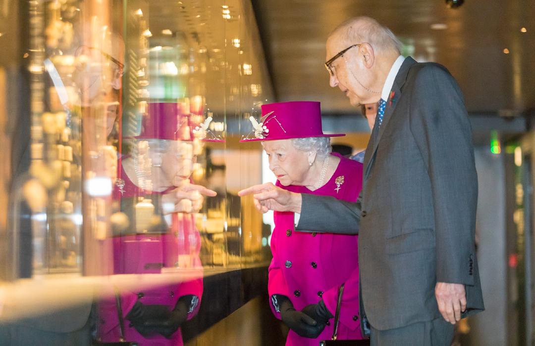 La Reine avec Sir Joseph Hotung, qui pointe un objet dans une armoire en verre. 
