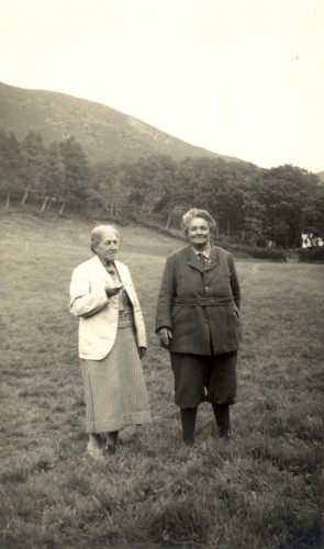 Photo en noir et blanc de May en jupe et veste et Mary en pantalon et manteau.